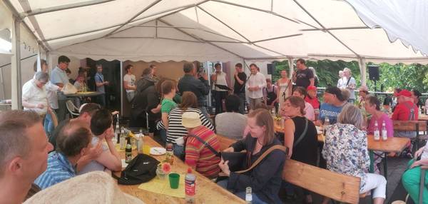 Viele Besucher an Tischen, die der Band TonRaum beim Auftritt zuschauen