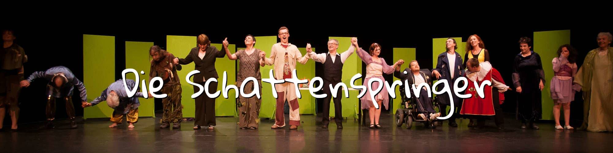 Die Theatergruppe Die Schattenspringer halten sich an der Hand beim Applaus des Publikums