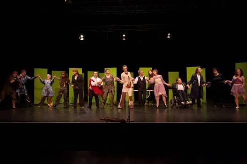 Alle Schauspieler*innen stehen nebeneinander auf der Bühne teilweise halten sie sich an den Händen und verbeugen sich