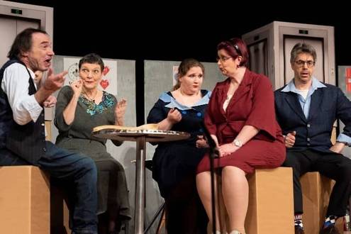 Menschen sitzen an einem runden Tisch und diskutieren miteinander.