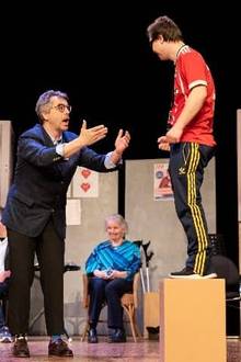 Ein Mensch steht auf dem Boden und spricht mit einem Mensch auf einem kleinen Sockel.